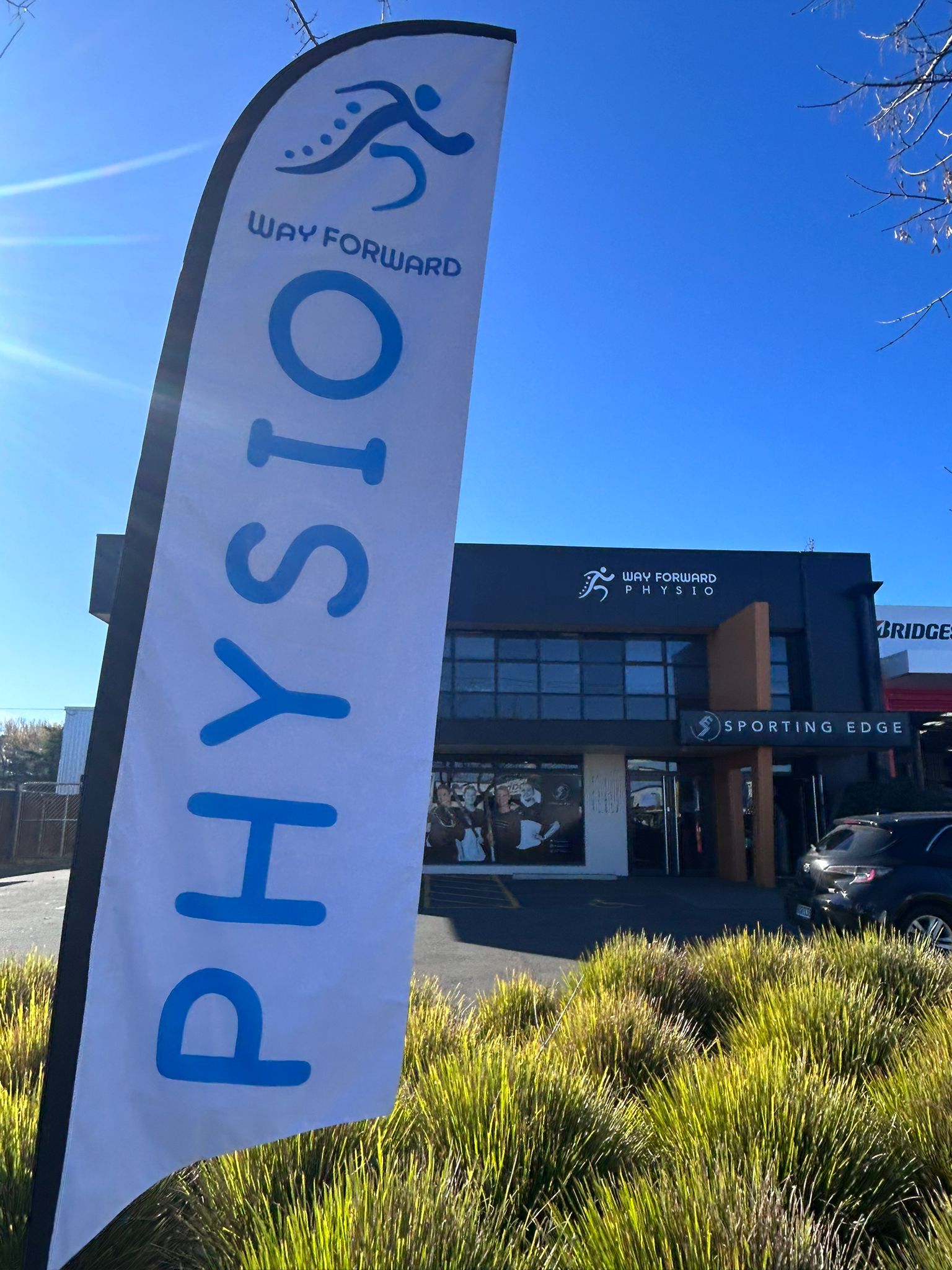 Way Forward Physio branded feather flag outside the clinic